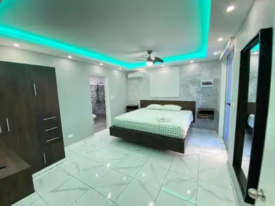 a bedroom with a bed and a blue ceiling at Hotel Checo Sosúa in Sosúa