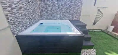 a jacuzzi tub in a bathroom with green grass at Villa vacacional Rikheriluz in La Romana