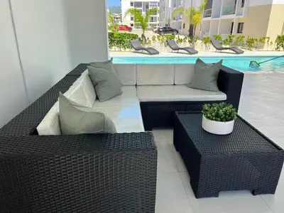 a patio with wicker furniture and a potted plant at 2 Bedrooms at Baia Residences in Santiago de los Caballeros