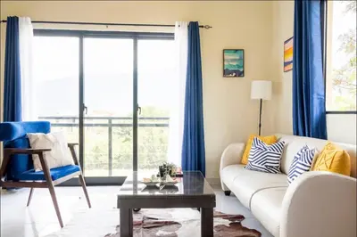 a living room with a white couch and blue curtains at Villa Ladera de la Montańa in Jarabacoa