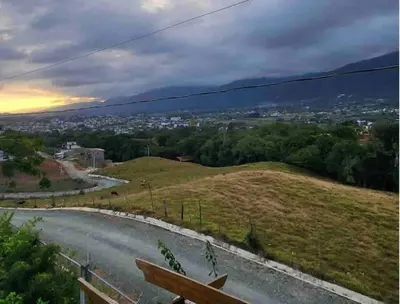 a winding road on a hill with a city in the distance at Villa Ladera de la Montańa in Jarabacoa