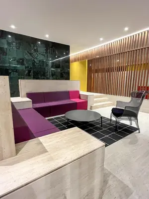 a lobby with a purple couch and a table and chairs at Acogedor Apartamento Céntrico in Santo Domingo