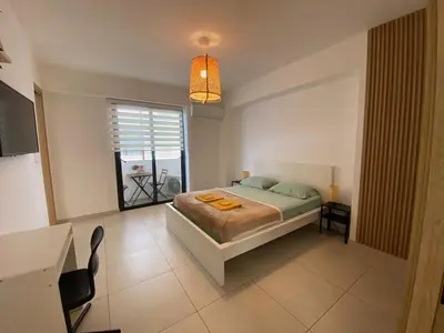a bedroom with a bed and a table and a window at Acogedor Apartamento Céntrico in Santo Domingo