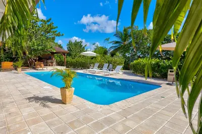 a swimming pool in a villa with palm trees at Río Mar Cumayasa in La Romana