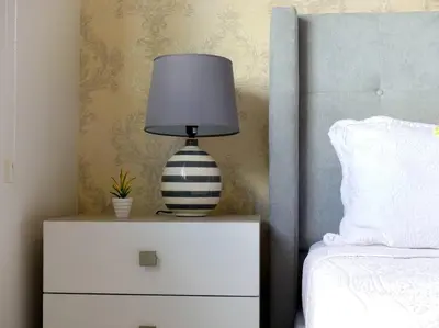 a black and white lamp on a night stand next to a bed at Dreams Room Soha II in Santiago de los Caballeros