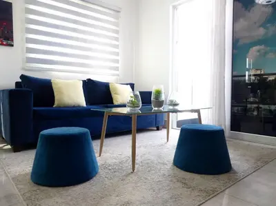 a living room with a blue couch and two blue stools at Dreams Room Soha II in Santiago de los Caballeros