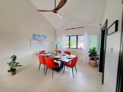 a dining room with a table and red chairs at Bright & Modern Apartment in Puerto Plata, Secure, and Central! in San Felipe de Puerto Plata