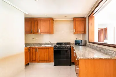 a kitchen with wooden cabinets and a black dishwasher at Gateway For You And Your Loves Ones I Sleeps 6 in Santo Domingo