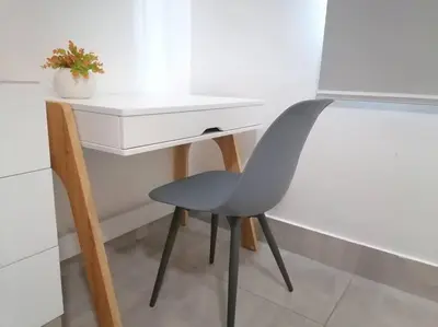 a blue chair sitting next to a white desk at Suites Room Soha II in Santiago de los Caballeros