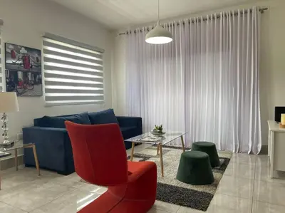 a living room with a blue couch and a table at Suites Room Soha II in Santiago de los Caballeros