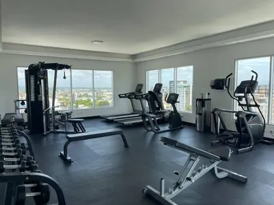 a gym with several treadmills and machines in a room at Suites Room Soha II in Santiago de los Caballeros