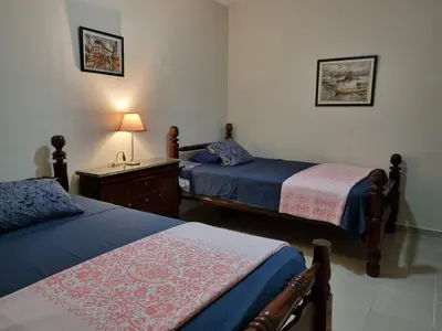 a bedroom with two beds and a table with a lamp at Your Little Paradise - Juan Dolio in Juan Dolio