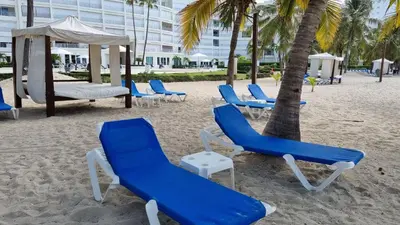 a group of chairs and a swing on the beach at Your Little Paradise - Juan Dolio in Juan Dolio