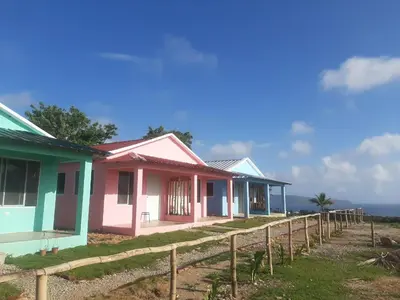 a row of houses in front of the ocean at Oasis en la naturaleza Rancho alto bonito in Las Galeras