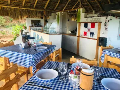 a dining room with two tables and a kitchen at Oasis en la naturaleza Rancho alto bonito in Las Galeras