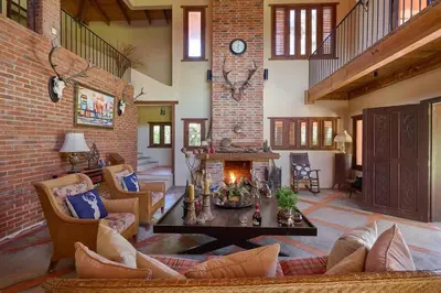 a living room with a table and a fireplace at Escape Chalet at Pinar del Sol in Jarabacoa in Jarabacoa