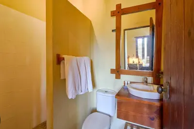 a bathroom with a sink and a toilet and a mirror at Escape Chalet at Pinar del Sol in Jarabacoa in Jarabacoa