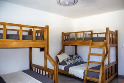 a bedroom with three bunk beds and a ladder at Villa Mónaco Jarabacoa RD in Jarabacoa