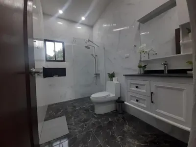 a white bathroom with a toilet and a sink at Villa Mónaco Jarabacoa RD in Jarabacoa