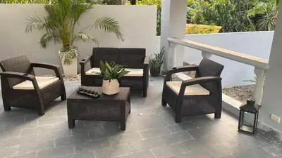 a group of chairs and tables on a patio at Villa Mónaco Jarabacoa RD in Jarabacoa
