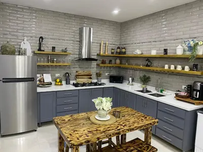 a kitchen with blue cabinets and a table with flowers on it at Villa Mónaco Jarabacoa RD in Jarabacoa