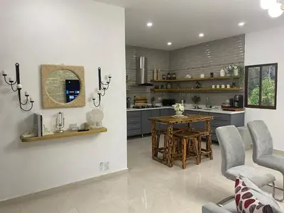 a kitchen with a table and chairs and a dining room at Villa Mónaco Jarabacoa RD in Jarabacoa