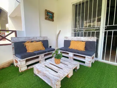 two chairs and a bench sitting on a porch at Xarraca, excepcional apartamento in Bayahibe