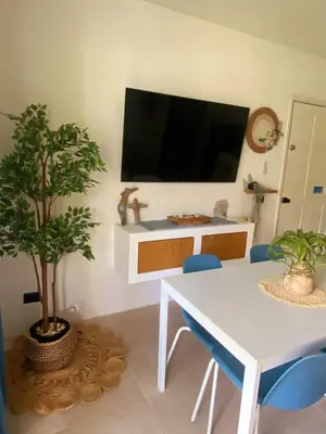 a dining room with a white table and a tv at Xarraca, excepcional apartamento in Bayahibe
