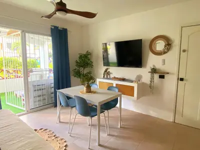a dining room with a table and chairs and a tv at Xarraca, excepcional apartamento in Bayahibe