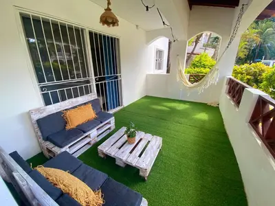 a balcony with a table and a couch and green grass at Xarraca, excepcional apartamento in Bayahibe