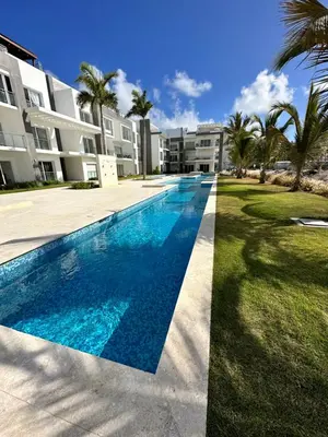 a swimming pool in front of a building at LUXURY CONDO Cana Bay 1 CLUB BEACH in Punta Cana