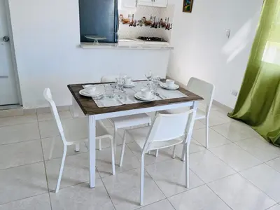 a dining room table with white chairs and a wooden table at Complejo girasol in Santo Domingo