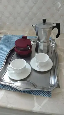 a tray with a coffee pot and saucers on a table at Complejo girasol in Santo Domingo