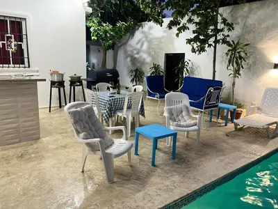 a group of chairs and tables next to a pool at Complejo girasol in Santo Domingo