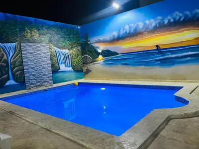 a swimming pool with a mural on the wall at Complejo Giraflor in Pantoja