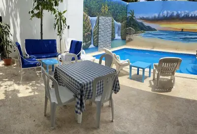 a table and chairs next to a swimming pool at Complejo Giraflor in Pantoja