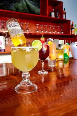 two cocktails sitting on top of a wooden table at The White Rock Hotel B&B in Los Conucos