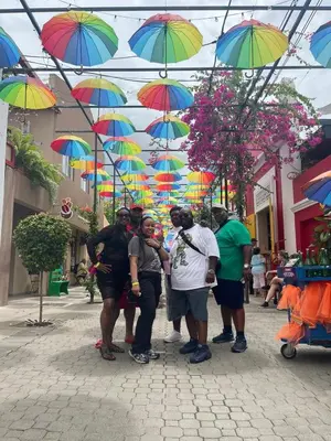 a group of people standing under colorful umbrellas at J&W apartment in San Felipe de Puerto Plata