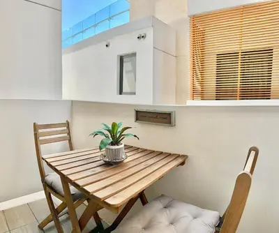 a dining room with a wooden table and two chairs at Confort y estilo en Galería 360 con piscina y gimnasio in Santo Domingo