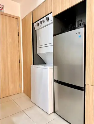 a kitchen with a stove and a refrigerator at Confort y estilo en Galería 360 con piscina y gimnasio in Santo Domingo