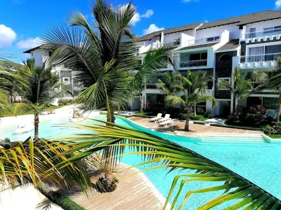 a view of a resort with a pool and palm trees at Caribbean Star - Estrella Dominicus Bayahibe in Bayahibe