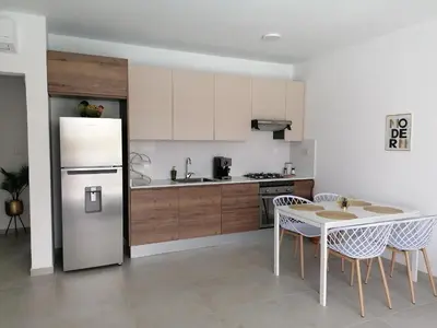 a kitchen with a refrigerator and a table and chairs at Caribbean Star - Estrella Dominicus Bayahibe in Bayahibe