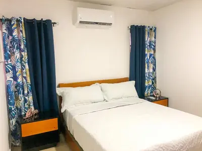 a bedroom with a bed and a window with curtains at Ocean View Apart. In Down town in San Felipe de Puerto Plata
