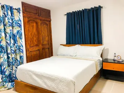 a bedroom with a bed and a blue curtain at Ocean View Apart. In Down town in San Felipe de Puerto Plata