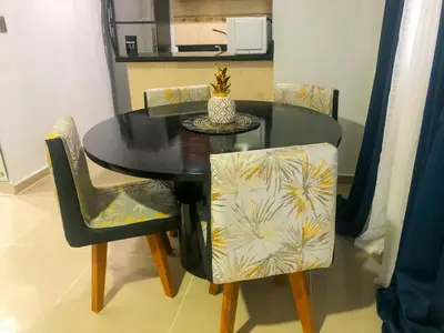 a black dining room table with chairs and a vase on it at Ocean View Apart. In Down town in San Felipe de Puerto Plata