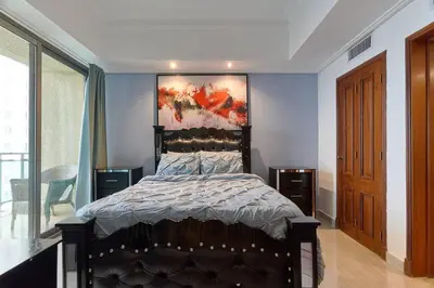 a bedroom with a bed with a painting on the wall at Luxurious Ocean View Suite in Santo Domingo