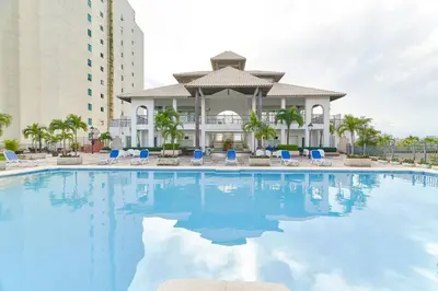 a large swimming pool with chairs and a building at Luxurious Ocean View Suite in Santo Domingo