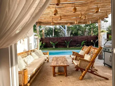 a patio with couches and a table and a grill at Villa Saule in Bombita