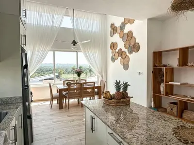 a kitchen with a table and a dining room at Villa Saule in Bombita