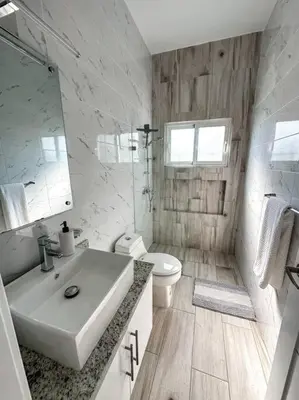 a white bathroom with a sink and a toilet at Villa Saule in Bombita